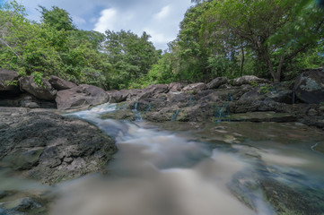 Fototapeta na wymiar Deep forest waterfall with rocks in rainy season at Thailand - flowing cascade waterfall. Fantasy jungle landscape