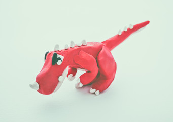 Red dinosaur clay model. Play dough animal. Vintage tone effect.