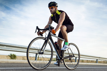 Handsome young man cycling on the road.