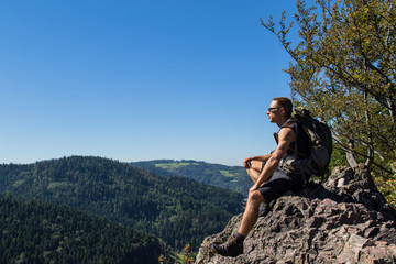 Junger Wanderer sitzt auf einem Gipfel des Karlsruher Grat und genießt die Landschaft