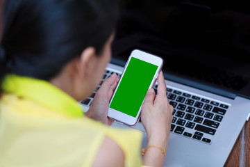 Woman's hands using cell phone and laptop computer on floor wood