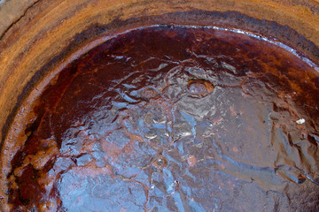 Rusty polluted water by oxidation with metal.Iron oxides stain the water brown and form a crust on...