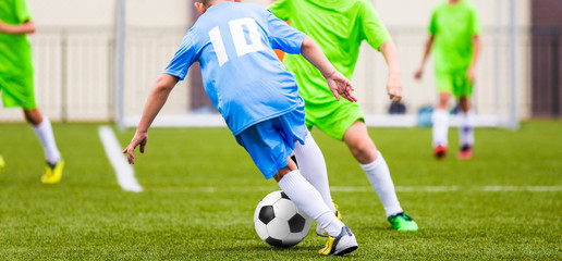 Obraz premium Kids Football Match. Boys Kicking Football Ball on Sports Field.