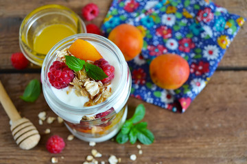 Homemade yogurt with granola, almonds, peaches and raspberries o