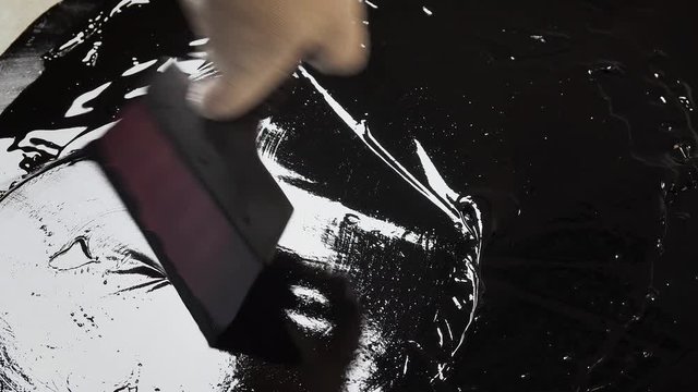 Work with a spatula on the bitumen on the surface