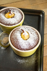 Freshly cooked traditional autumn dessert: pear with chocolate; charlotte. On a baking sheet, on a wooden table