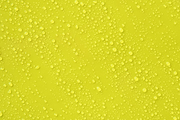 Water drop on yellow background.
