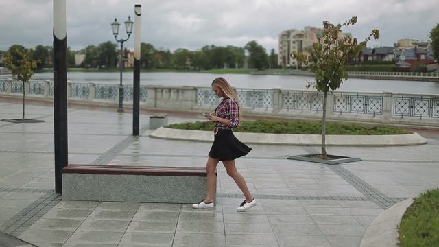 Young woman with smartphone walking in the city
