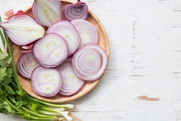 Red onion slices on rustic wooden table background