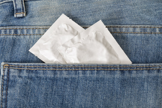 Condoms in the pocket of a blue jeans closeup