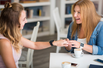 Positive mother and daughter sitting at the table