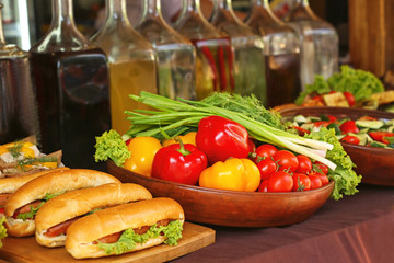 Fresh vegetables, different drinks and sandwiches on counter