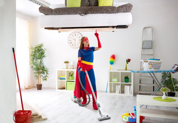 Worth super hero woman in costume use vacuum cleaner