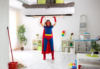 Woman in super hero costume holding bad in the air
