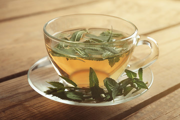 Cup of sage tea on wooden background