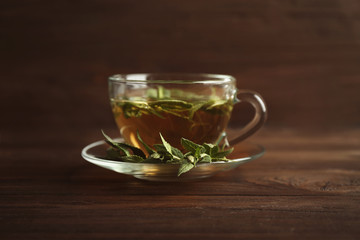 Cup of sage tea on wooden background