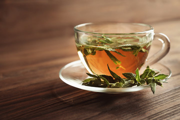 Cup of sage tea on wooden background