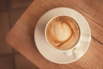 Cup of coffee with meringues on wooden table