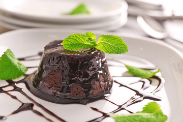 Chocolate fondant cake with mint on the plate, closeup