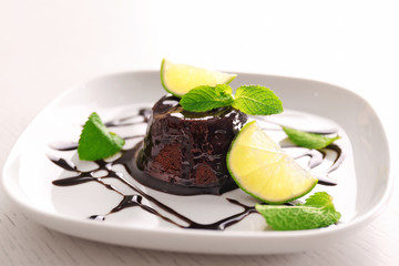 Chocolate fondant cake with mint and lime on the plate