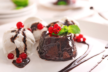 Chocolate fondant cake with red currant and ice cream on the plate