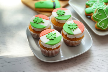 Tasty cupcakes with clover on plate. Saint Patrics Day concept