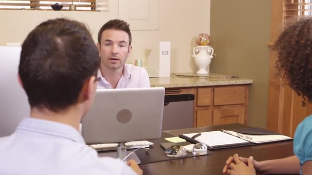 Man speaking to two associates in office