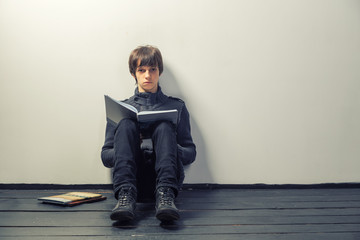 young student man reading books on wooden floor