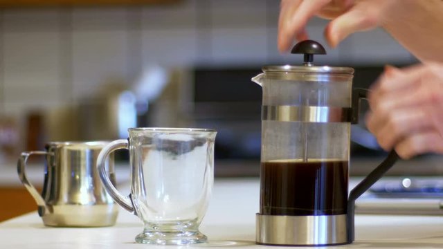 Slow motion footage of coffee being poured into a glass mug.
