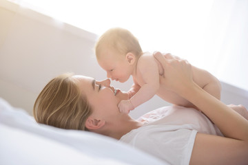 Happy mother holding up her baby girl