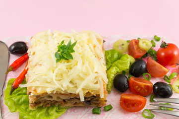 Lasagna portion served with fresh vegetables