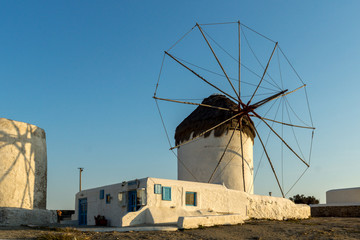 Fototapeta na wymiar Amazing Sunset and White windmills on the island of Mykonos, Cyclades, Greece