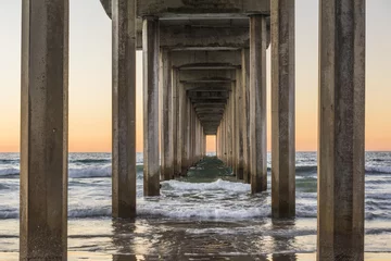 Fotobehang Slaapkamer Symmetrisch schot onder Scripps Pier met golven tijdens zonsondergang in La Jolla, San Diego, Californië