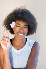 Close up portrait of a young woman smiling with afro hair agains