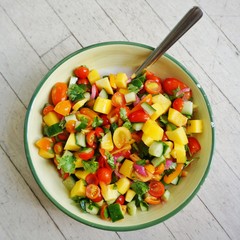 A bowl of fresh tomato, mango, and cilantro salsa