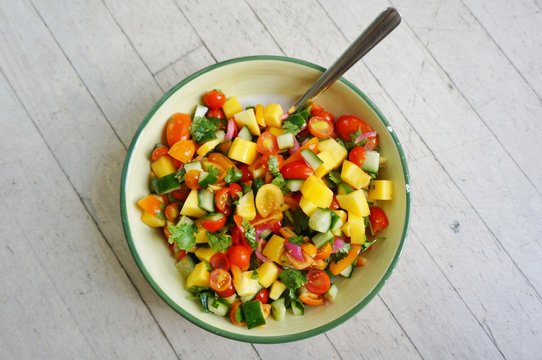 A Bowl Of Fresh Tomato, Mango, And Cilantro Salsa