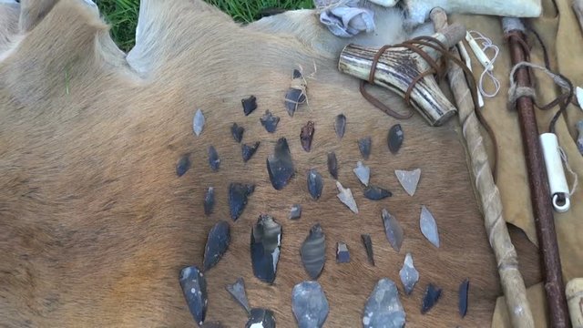Arrows and knifes made of flint and various obsolete tools placed on fur in historic far festival