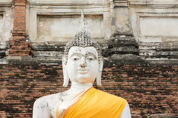 Close-up old Buddha image in yellow robe