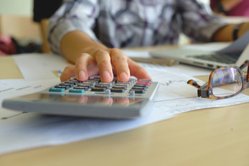Fototapeta premium Asian Business woman using a calculator to calculate the numbers vintage tone