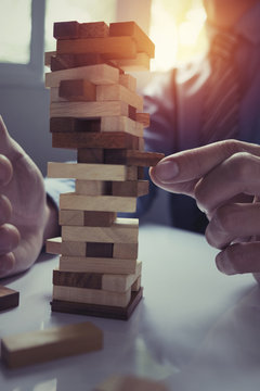 business man placing wooden block on a tower concept risk control, Planning and strategy in business