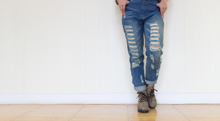 jeans woman wearing jeans and wearing brown leather shoes. Standing against a white wall