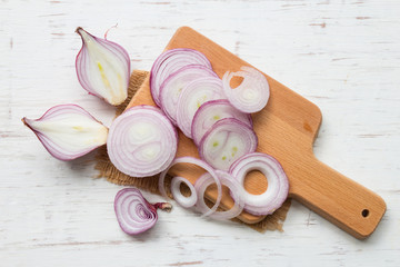 Fototapeta na wymiar Red onion slices on rustic wooden table background