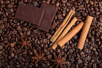 Chocolate and cinnamon on coffee beans background