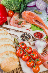 Fish filets and shrimps on rustic table with spices