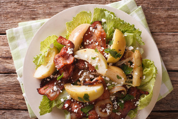 Warm salad with bacon, onions, green apple and goat cheese. horizontal top view
