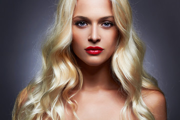 Fototapeta premium luxury beautiful young woman with healthy curl blond hair. long wavy hair girl with make-up