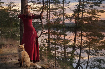 Young woman aiming with bow and arrow