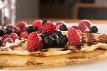 Fresh, golden pancakes with fruit and cream