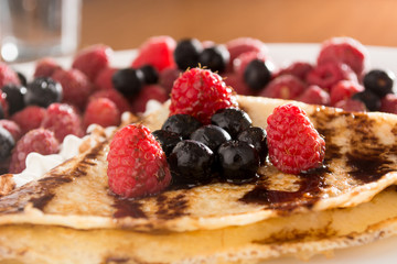 Fresh, golden pancakes with fruit and cream