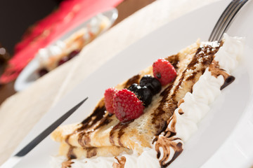 Fresh, golden pancakes with fruit and cream